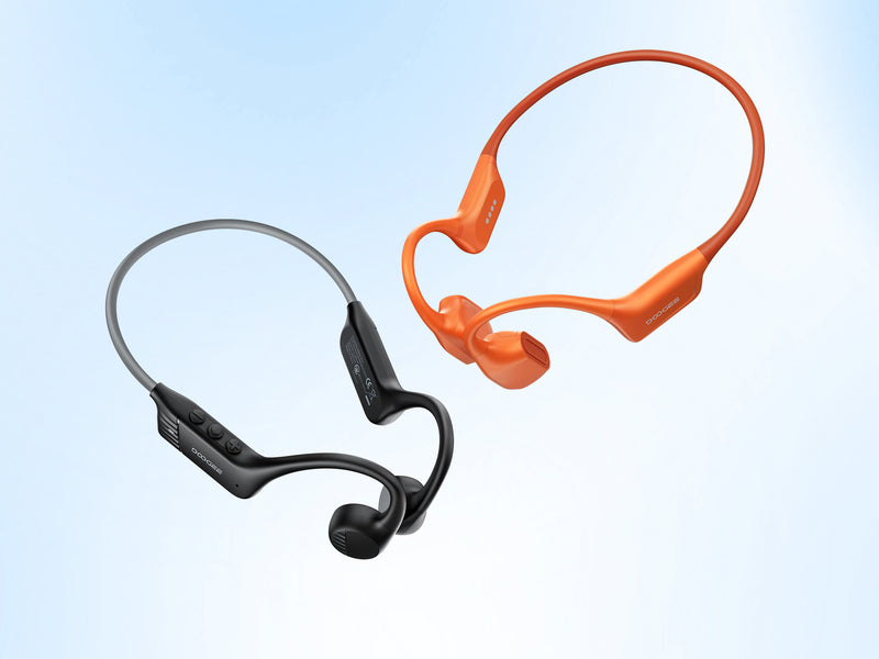 Black and orange wireless earbuds on a light blue background